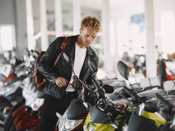 homme à la recherche d'une moto d'occasion chez un concessionnaire