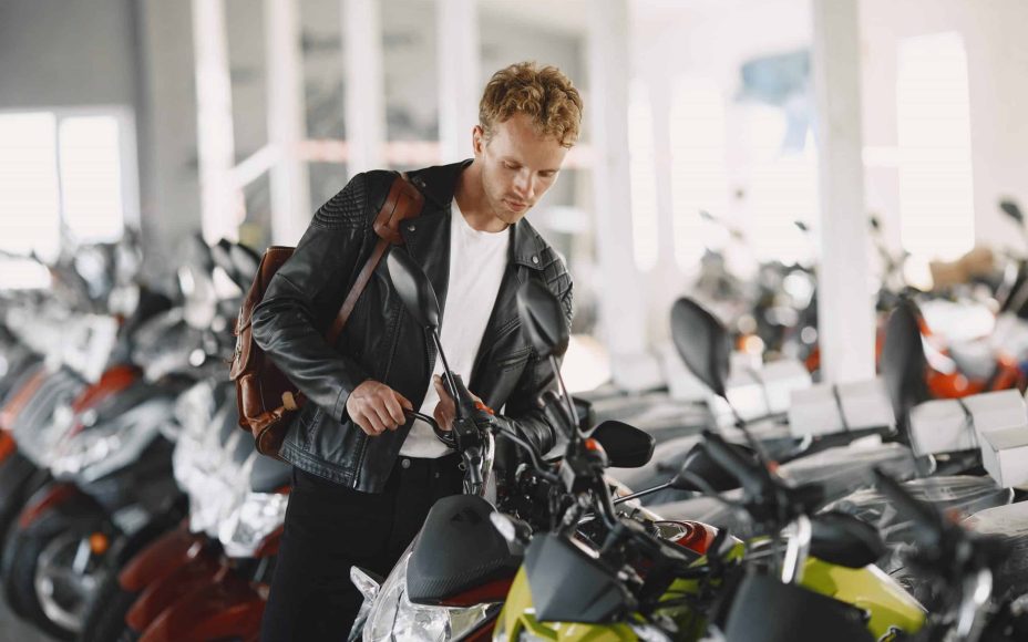 homme à la recherche d'une moto d'occasion chez un concessionnaire